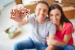 couple holding up a set of house keys - FHA Loan